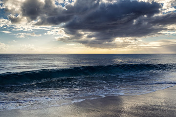 Evening view with sun shining throug clouds at Makua beach, Oahu, Hawaii