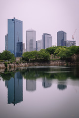 Fototapeta na wymiar Osaka city modern downtown building with reflection in water