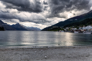 Evening view of dramatic clouds over Wakatipu lake and mountains of Queenstown, New Zealand
