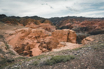 Charyn Grand Canyon with clouds and sun red orange stone Martian landscape