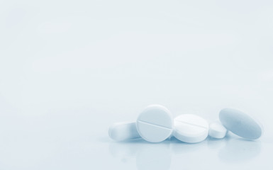 Pile of white round, oblong, and oval shape tablet pills isolated on white background. Pharmaceutical industry. Pharmacy or drugstore sign and symbol. Pharmacy background. Health and pharmacology.