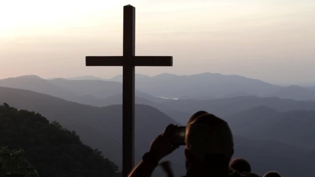 A tourist takes a picture of the cross at pretty place chapel SC.