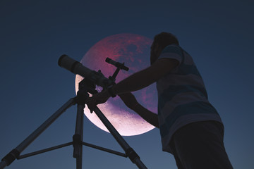 Fototapeta Man looking at lunar eclipse through a telescope. My astronomy work. obraz