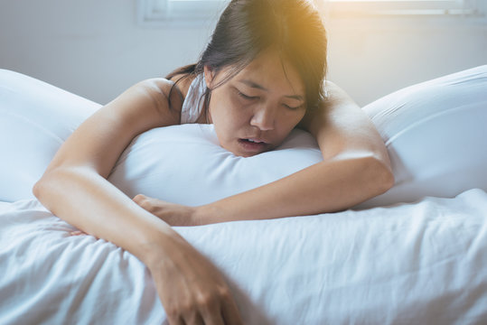 Asian woman snoring because due to tired of work,Female snor while sleeping on bed