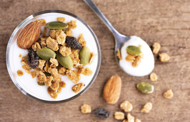 A breakfast of yogurt with dried fruit placed on a wooden table.