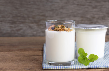A breakfast of yogurt with dried fruit put on a wooden table.
