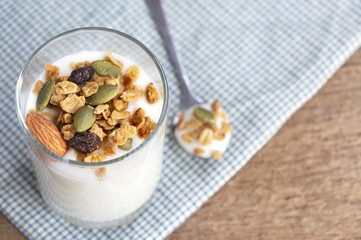 A breakfast of yogurt with dried fruit put on a wooden table.