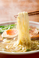 熱々の醤油ラーメンを箸で摘む © Tsuboya