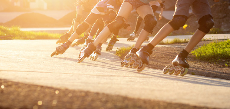 Group Of Teenagers Skating On Track In Summer Evening. Abstract Panoramic Short Track Speed Skating Sport Background