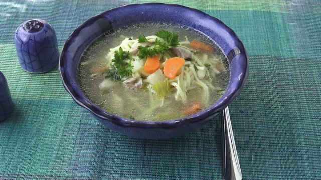 Chicken noodle soup - broth. Traditional chicken soup served in a bowl.
