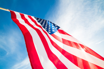 Fototapeta premium Close up United States of America flag on the blue sky background. USA Independence day, 4 July.