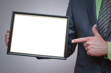 Blank diploma or certificate mock up in businessman hand. Empty photo frame border with copy space.