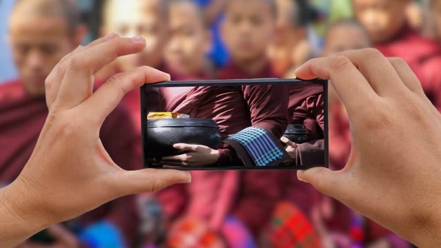 Cinemagraph of Taking Photo of Alms Giving Ceremony. Burmese Monks Walk and Gather Food. Tak Bat in Mandalay