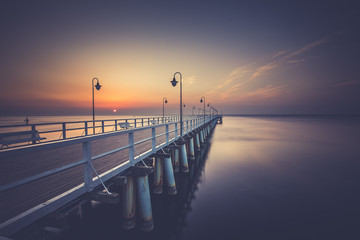 Obraz premium Amazing colorful sunrise over the pier in Gdynia Orlowo. Sunrise over the sea.