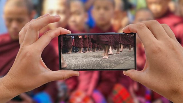Cinemagraph of Taking Photo of Alms Giving Ceremony. Burmese Monks Walk and Gather Food. Tak Bat in Mandalay