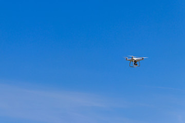 Fototapeta na wymiar Drone with camera flying in blue sky