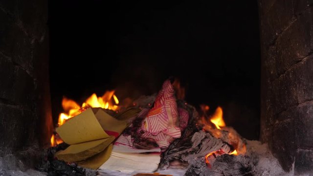 Burning spirit money paper in a  ghost money stove