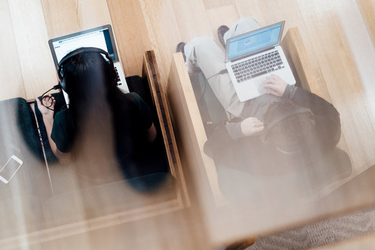 two students work on laptops