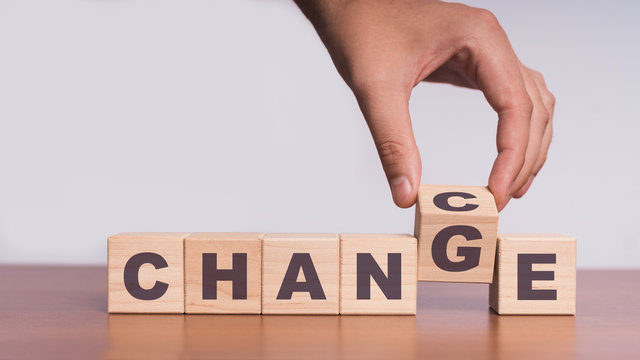 Hand hold flip wooden cube with word "change" to "chance"