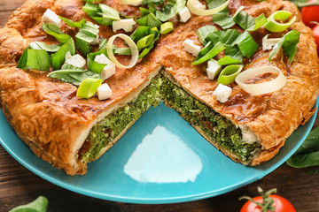Tasty pie with spinach on table