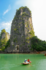 A beautiful rock and a boat with two fishermen at the cave of Hang Sung Sot in Halong Bay. Vietnam