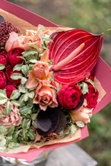 Beautiful red summer bouquet. Arrangement with mix flowers. Young girl holding flower arrangement . The concept of a flower shop. Content for the catalog