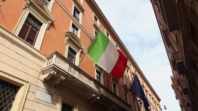 Italian flag moving slowly in wind. Europe union flag in back ground. Day time