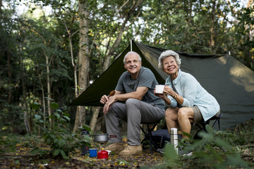 Senior friends having coffee at a campsite