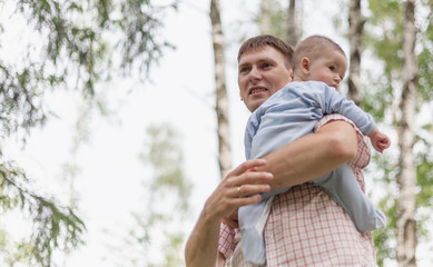 A young man with his young child an infant in his arms, on the street