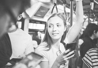 Young woman using a smartphone in the subway