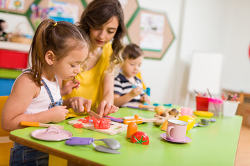 Fototapeta premium Childs are playing with play clay in classroom 