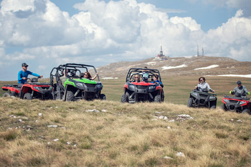 Friends driving off-road with quad bike or ATV and UTV vehicles