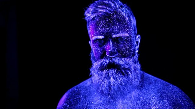 Portrait of a bearded man painted in ultraviolet powder