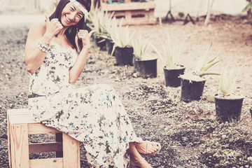 hippy style dress and hair lady like '70s sitting on a wood bench made my recycled materials outdoor light and relaxed lady in leisure activity outside