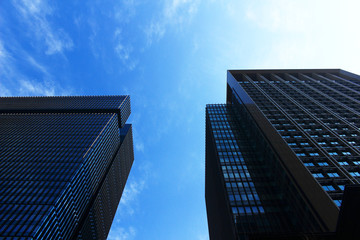 Fototapeta na wymiar Two office buildings standing under the blue sky