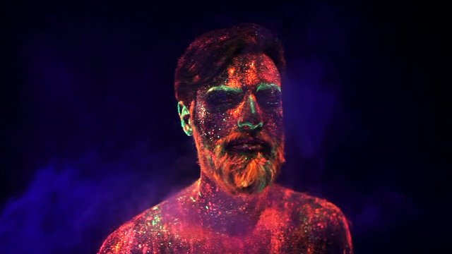 Portrait of a bearded man in ultraviolet light in smoke