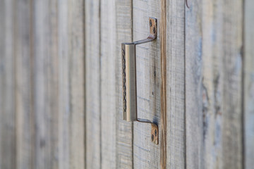 an old wooden wall and adoor with a long metal handle ina country style