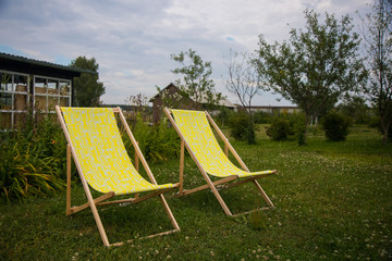 Two yellow chairs in the summer green  garden for relax