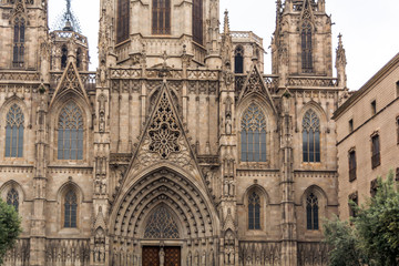 Facade of Barcelona Cathedral, or The Cathedral of the Holy Cross and Saint Eulalia in the Gothic Quarter of Barcelona. Facade is decorated with statues, pinnacles, arches.