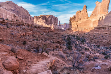 Fototapeta premium Hiking though Park Avenue, we caught an overlook view of the path through the rock formations in Arches National Park, Utah.