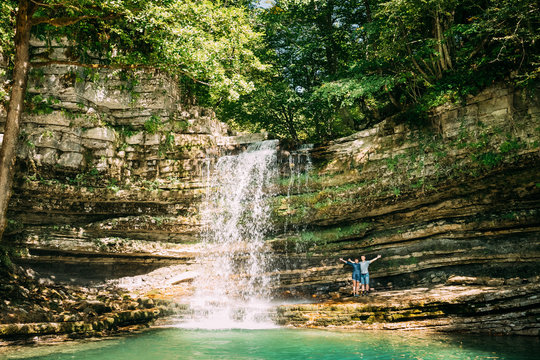 Young People Enjoy Nature Near Small Waterfall In Okatse River. 