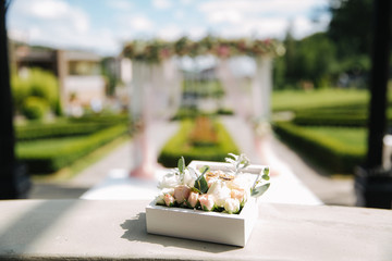 Wedding rings in little floral box. Beautiful beckground of wedding arch