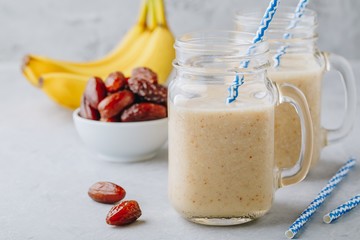 Smoothie aux fruits à la banane et aux dattes ou milkshake dans un bocal en verre