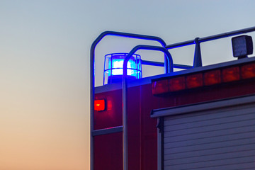 Flashing lights of red fire truck at dusk
