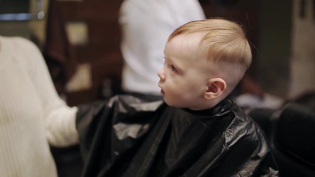 Baby first hair cut time in a hairdressing salon