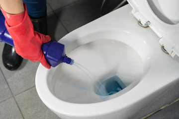 hand cleaning toilet bowl with a detergent