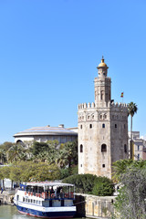 Fototapeta na wymiar Spain, Seville, Torre del Oro, the Golden tower and cruise boat on the river Guadalquivir