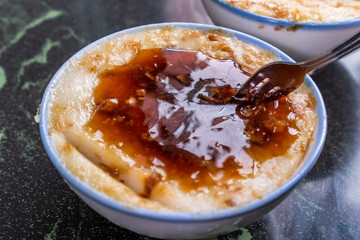 Taiwan's distinctive famous snacks: Savory rice pudding (Wa gui) in a white bowl on stone table, Taiwan Delicacies, Taiwan Street Food