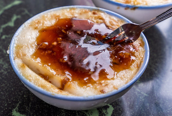 Taiwan's distinctive famous snacks: Savory rice pudding (Wa gui) in a white bowl on stone table, Taiwan Delicacies, Taiwan Street Food
