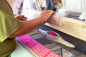 The hands of old woman weaving, the ancient weaving method.